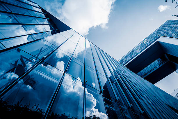 blue sky and clouds reflected at glass wall stock photo