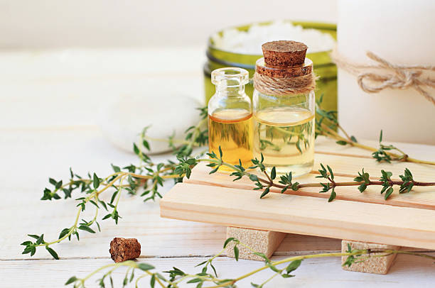 Thyme Herb Aromatherapy treatment. Botanic Spa. Thyme essential oil. Bottles with extract, fresh green plant leaves.  aromatherapy oil photos stock pictures, royalty-free photos & images