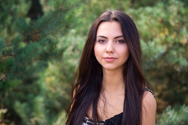 istock Graceful charming brunette model posing in black dress  coniferous park 626564312