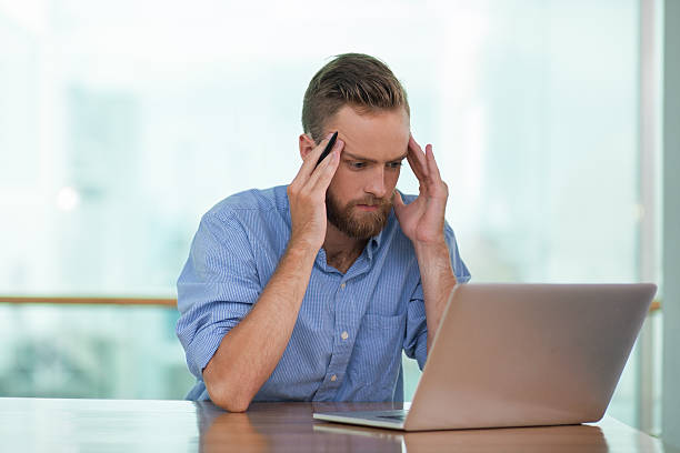 istock Tensed Young Man Working on Laptop at Cafe Table 626566046