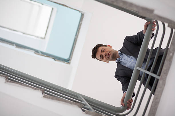 istock Serious middle-aged businessman on stairs 626569566