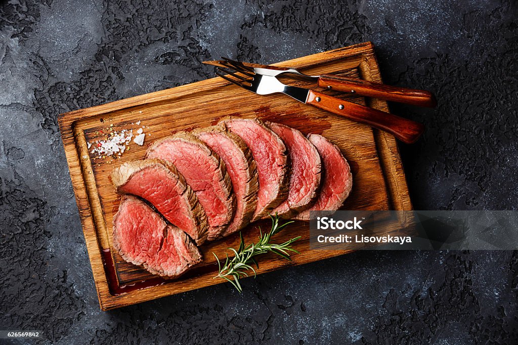 Sliced grilled tenderloin Steak roastbeef Sliced grilled tenderloin Steak roastbeef on wooden cutting board on dark background Tenderloin Stock Photo