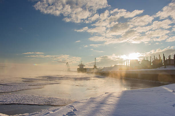 Beautiful winter industrial lanscape. Bulker in a Harbour, loading wood.