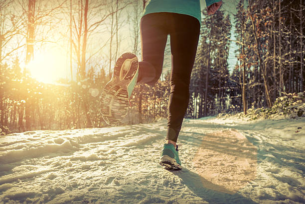 istock Woman Running at snowly winter under sunlight. 626572322