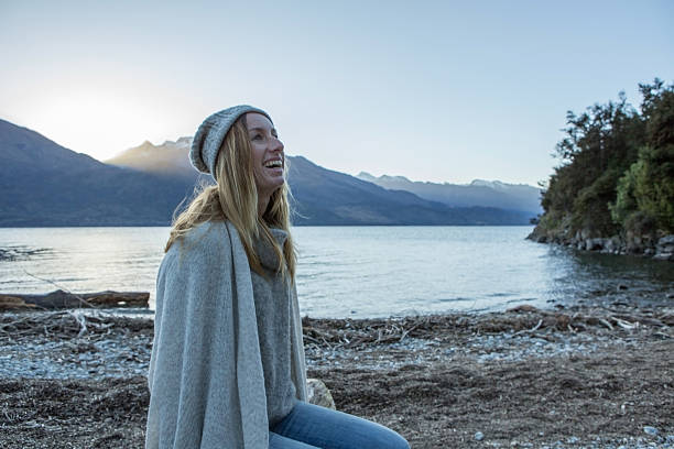 istock Young woman relaxing by the lake 626572890