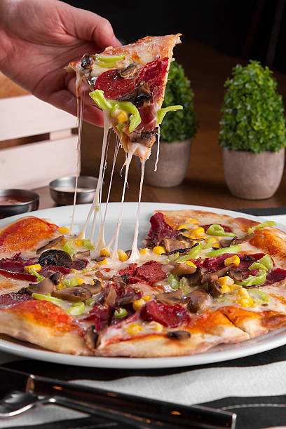 istock Young and beautiful Women hand holding a pizza with cheese 626573078