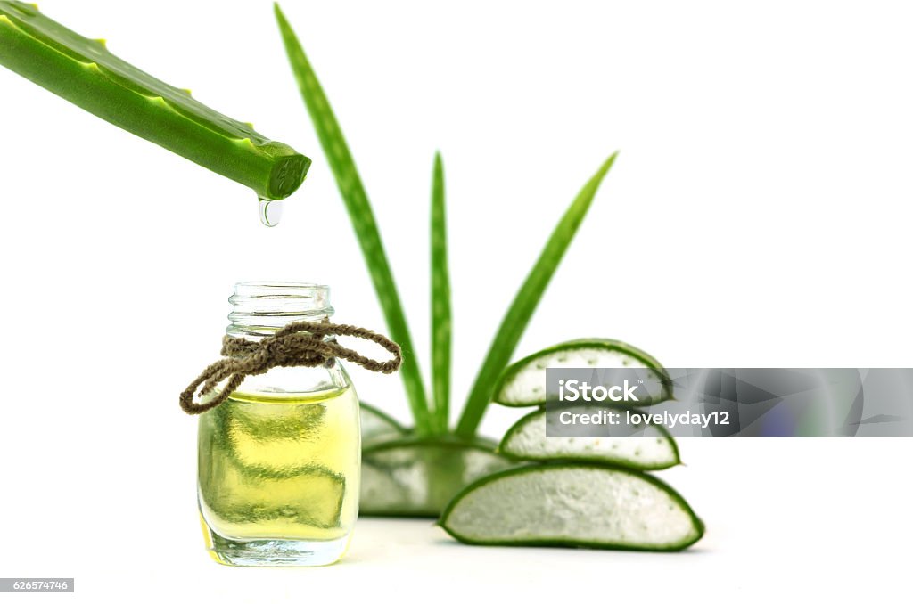 Aceite esencial de aloe vera sobre hojas tropicales sobre fondo blanco - Foto de stock de Fondos libre de derechos