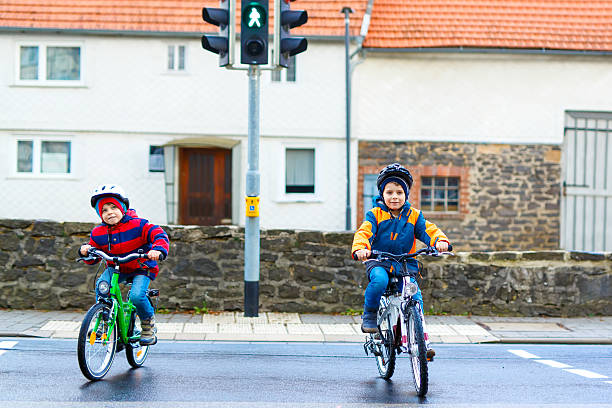 istock Two kids boys biking and waiting on traffic light 626575714