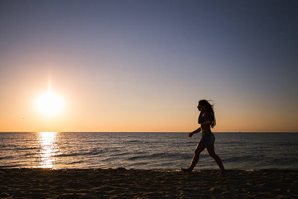 istock Woman running on the beach at sunset 626576976