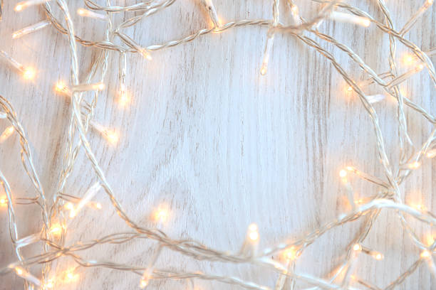 istock Christmas lights on white wooden background 626582918