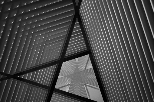 Reworked close-up photo of sloped walls / pitched roof / ceiling. Realistic though unreal industrial interior. Abstract black and white modern architecture background image.