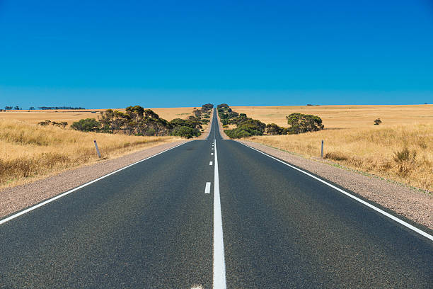 carretera australiana en línea recta en el interior rural - carretera de campo fotografías e imágenes de stock