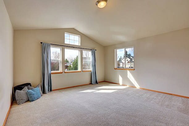 istock Empty room interior with beige carpet floor and vaulted ceiling 626590214