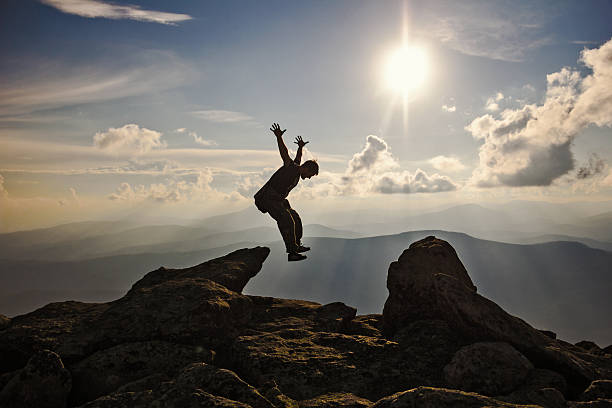 istock Hiker with backpack jumping over rocks  sunset sky on the 626590374