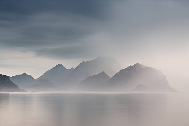 summer cloudy lofoten islands. norway misty fjords. - fog imagens e fotografias de stock