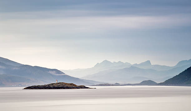 costa del mar de noruega. nubes de calima. faro en la roca - lofoten and vesteral islands beach nature norway fotografías e imágenes de stock