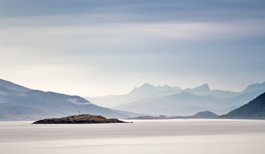 Coast of Norway sea. Clouds of haze. Beacon on rock