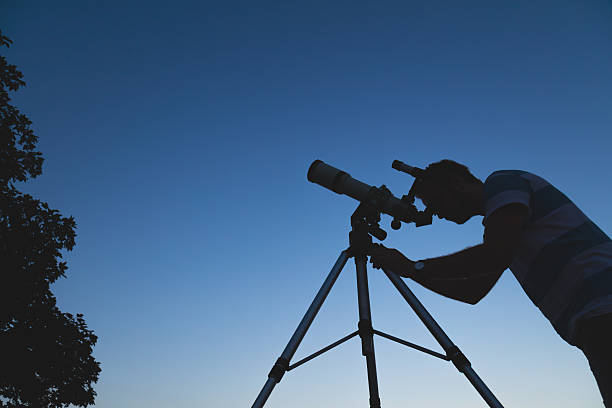 istock Man looking at the night sky through a telescope. 626591970