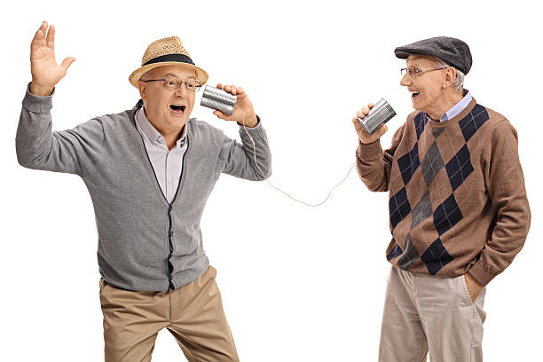 Cheerful seniors telling jokes through tin can phone