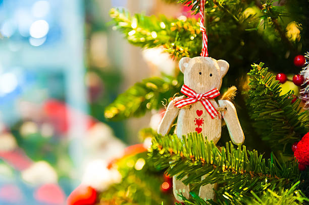 istock Old wooden toy bear with a red bow ribbon hanging 626608038