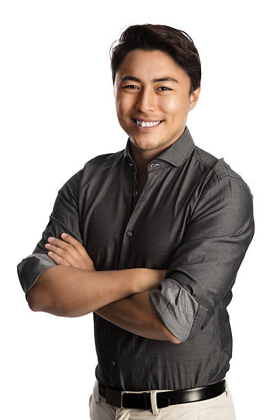 Handsome man in grey shirt arms crossed Relaxed good looking man standing against a white background wearing a grey shirt, smiling looking at camera. vibrant color lifestyles vertical close up stock pictures, royalty-free photos & images