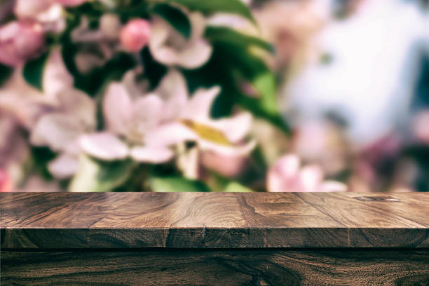istock Empty top wooden table and floral blurred background 626610972