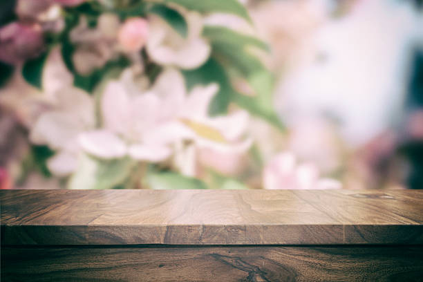 istock Empty top wooden table and floral blurred background 626611128