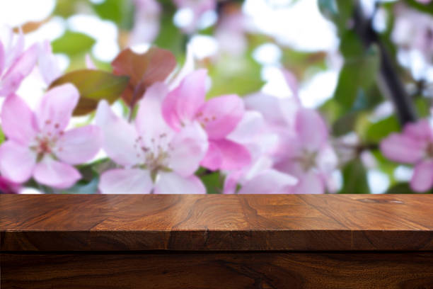 istock Empty top wooden table and floral blurred background 626611256