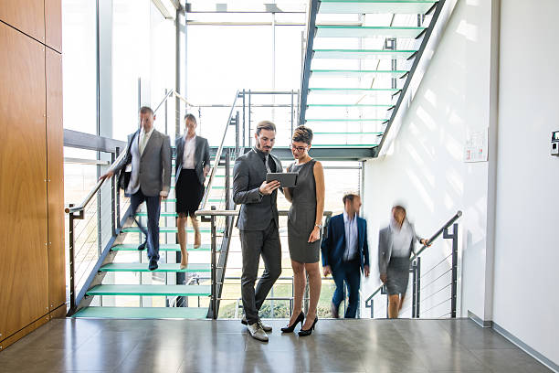 istock Young business people discussing business strategy using digital tablet 626611380