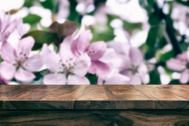 istock Empty top wooden table and floral blurred background 626611544