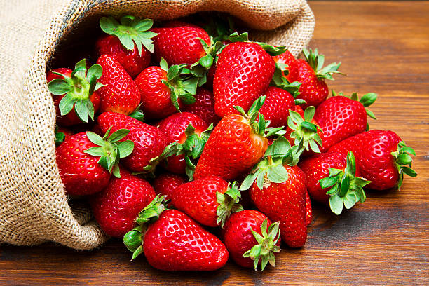 istock fresh strawberry in burlap sack on wood 626611904