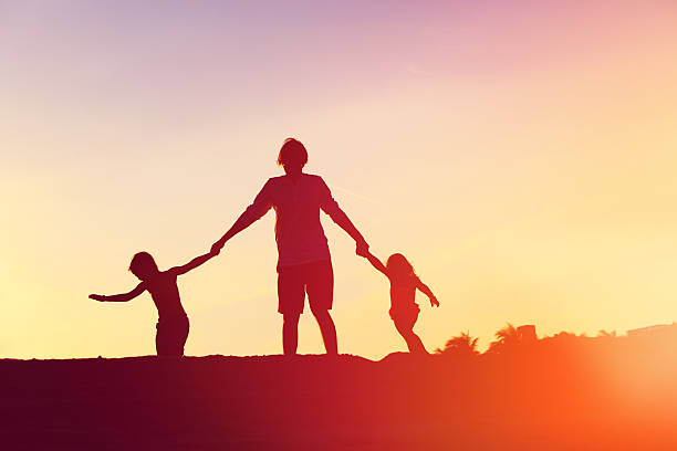 istock father with son and daughter silhouettes play at sunset 626612052