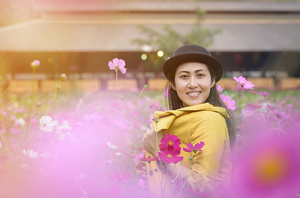 Portrait of thai women at the beautiful cosmos flowers field. stock photo