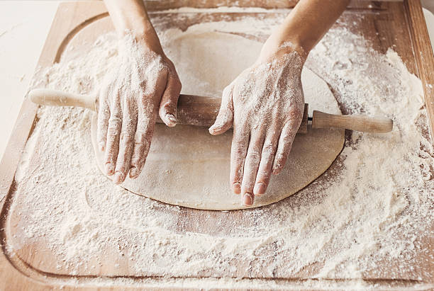 istock Hands baking dough with rolling pin on wooden table 626616772