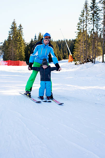 istock Kid learning to ski with help of ski instructor. 626618576