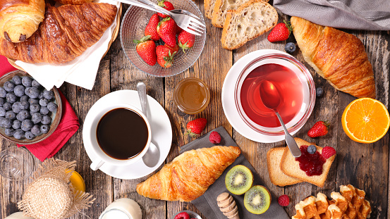 breakfast composition with coffee,tea,croissant and fruit