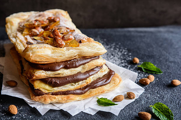 Chocolate and caramelized almond Mille-feuille Mille-feuille with chocolate cream and caramelized almond topping sprinkling powdered sugar stock pictures, royalty-free photos & images