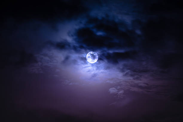 Nighttime sky with clouds and bright full moon with shiny. stock photo