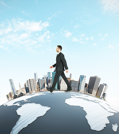 Businessman walking on abstract earth with cityscape on sky background. Urbanization concept. 3D Rendering