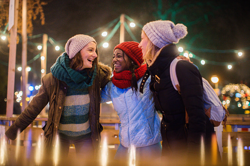 Photo of a cheerful friends spending time on Christmas market during holidays 