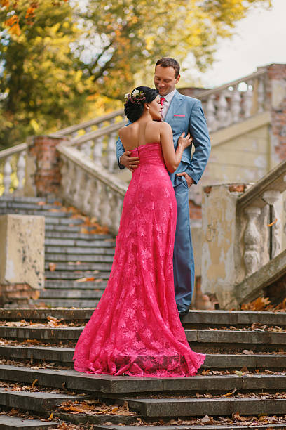istock Romantic couple on stairs, he gently looks at her. 626626024