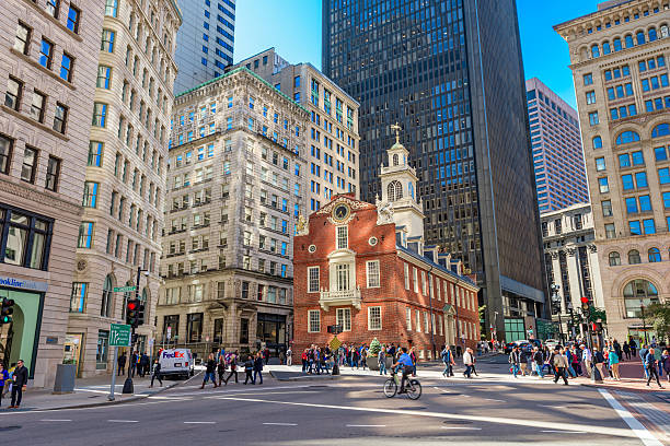 Streets of Boston Boston, Massachusetts, USA - October 14, 2016: Pedestrians cross at the Old State House in Boston. The building dates from 1713. boston skyline night skyscraper stock pictures, royalty-free photos & images