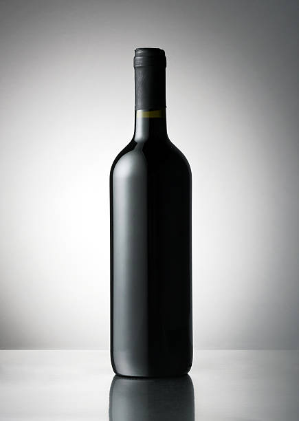 Lying red wine bottle. Small DOF. Isolated on white background