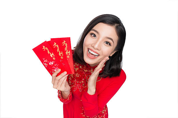 Happy Lunar New Year Portrait of a beautiful Asian woman on traditional festival costume Ao Dai holding red pocket - lucky money. Tet holiday. Lunar New Year. ao dai stock pictures, royalty-free photos & images