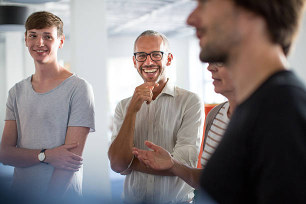 enjoying discussions in a stand up meeting - business men humor macho imagens e fotografias de stock