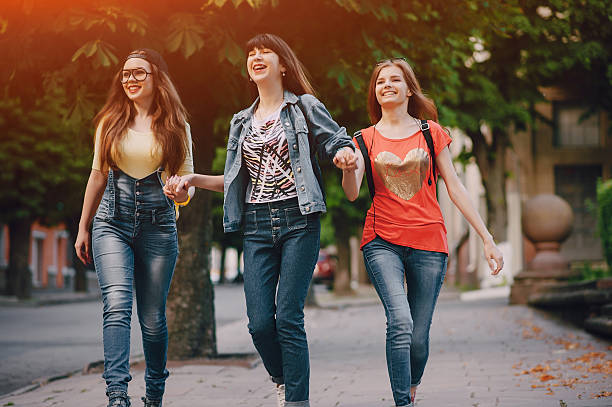 istock three young girls walking in the park 626632270