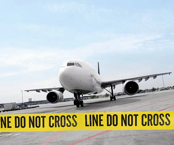 warning tape quoting "line do not cross" in from of an airplane