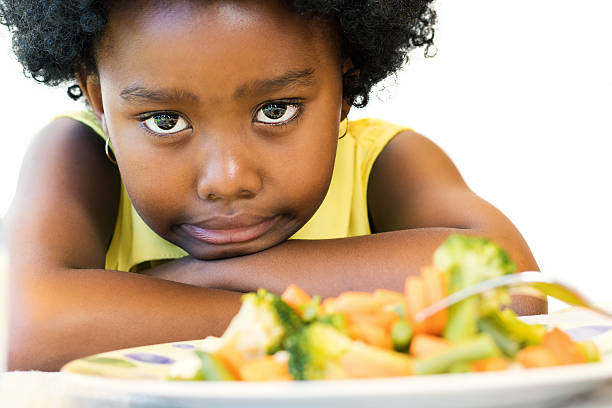 istock Little black girl pulling up nose for vegetables. 626639736