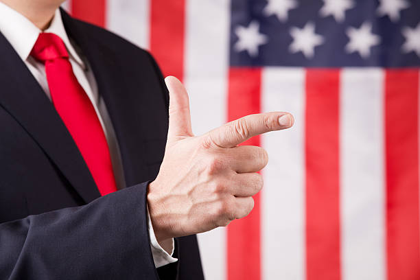 istock American Leader Pointing In Front Of US Flag 626642444