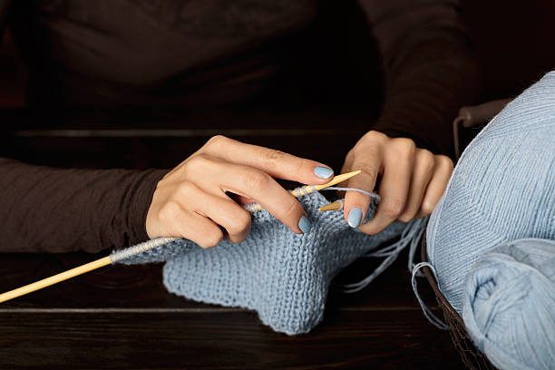 istock Female hands knitting from light blue yarn. 626642686